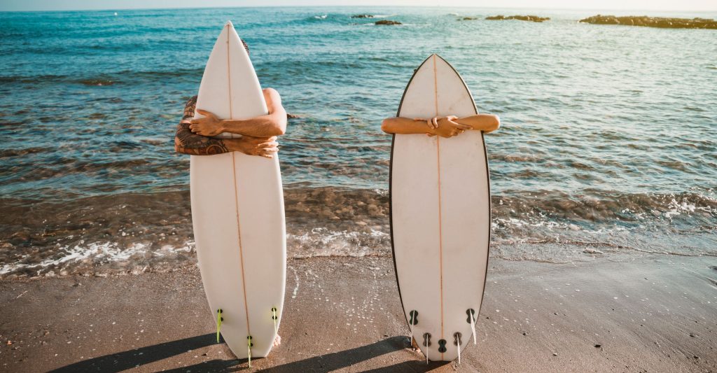 surfer hugging surfboard at the beach 
